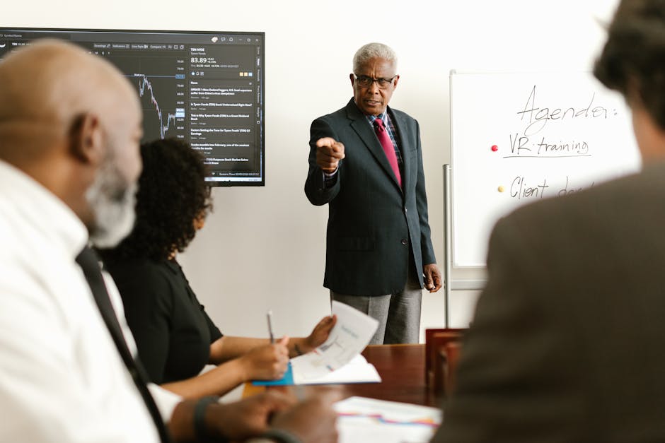 Senior executive conducting a business meeting with colleagues, discussing agenda on a whiteboard