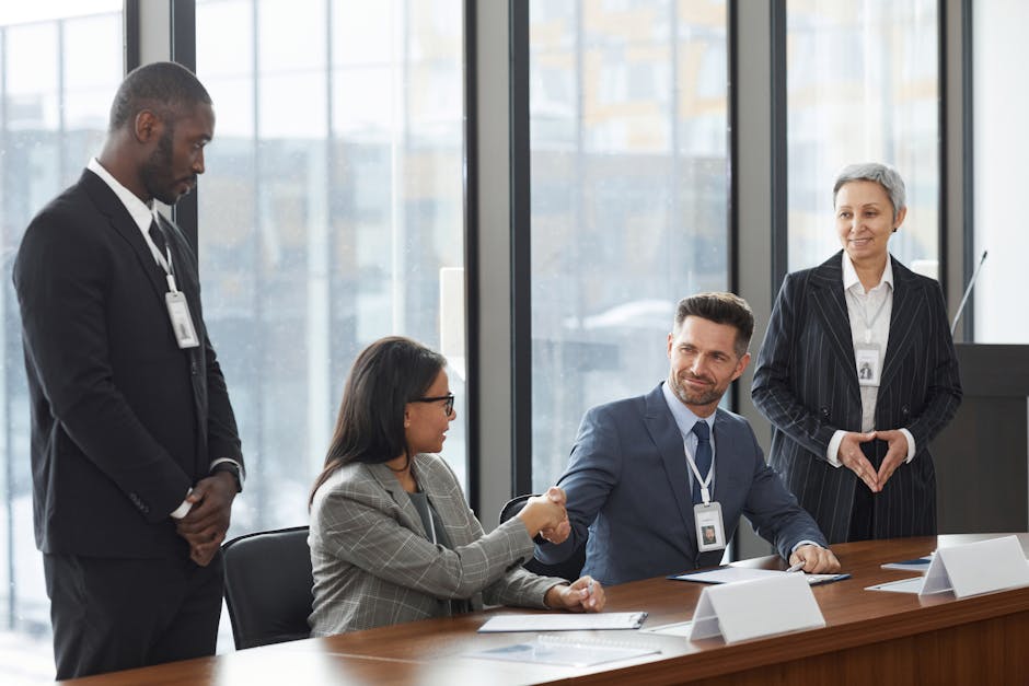 A diverse group of professionals shaking hands during a business meeting in a modern office